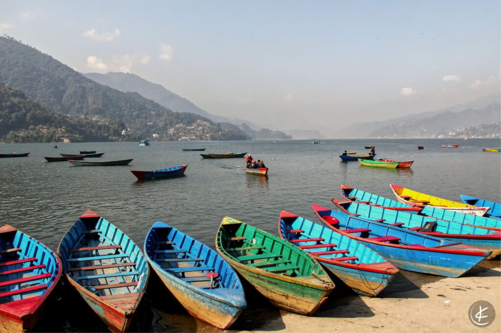 Bunte Boote im Hafen mit vielen Booten im Hintergrund auf dem See und Bergen