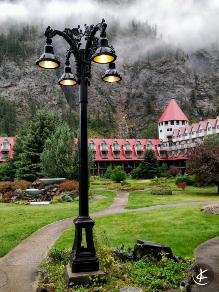 Laterne im Nebel mit Bergen und einem Hotel im Hintergrund